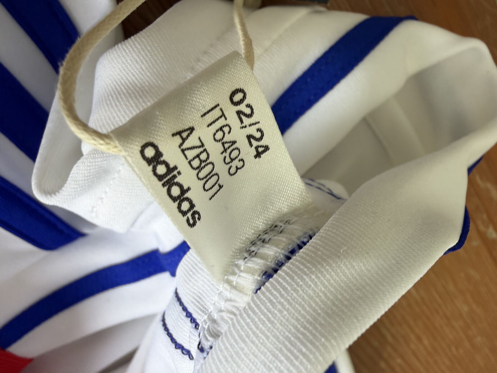 Woven interior label printed with 02/24, IT6493, AZB001 and the adidas wordmark