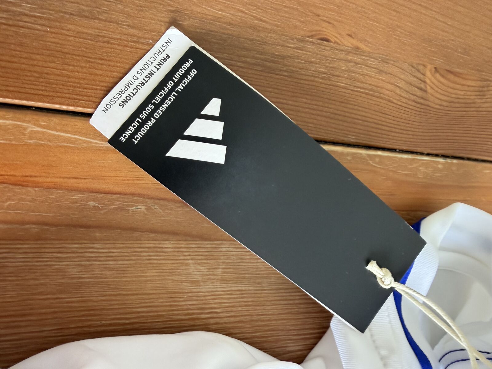 Reverse of the adidas hangtag reading OFFICIAL LICENSED PRODUCT / PRODUIT OFFICIEL SOUS LICENCE with the adidas logo