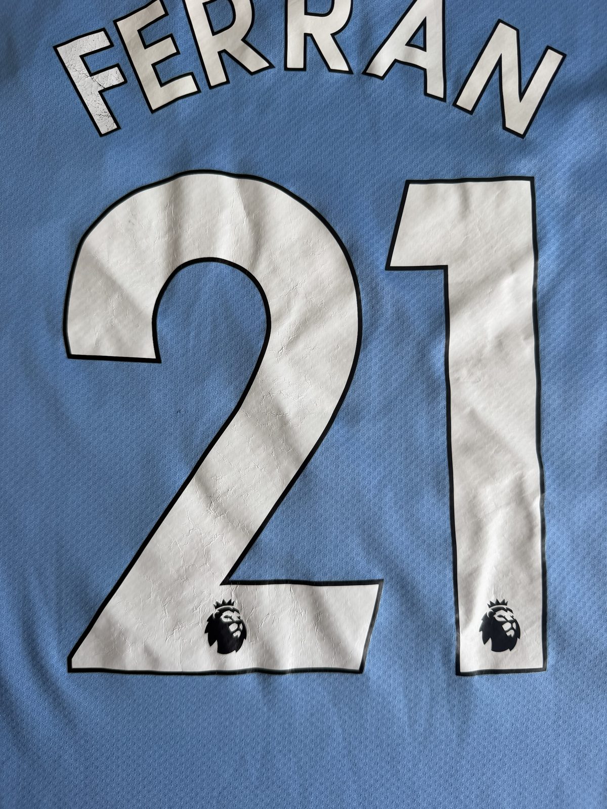 Close-up of the FERRAN 21 nameset on the back of the shirt showing surface cracking on the printed number